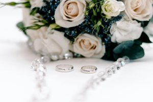 Close-up of bridal bouquet with wedding rings and decor elements, perfect for wedding themes.