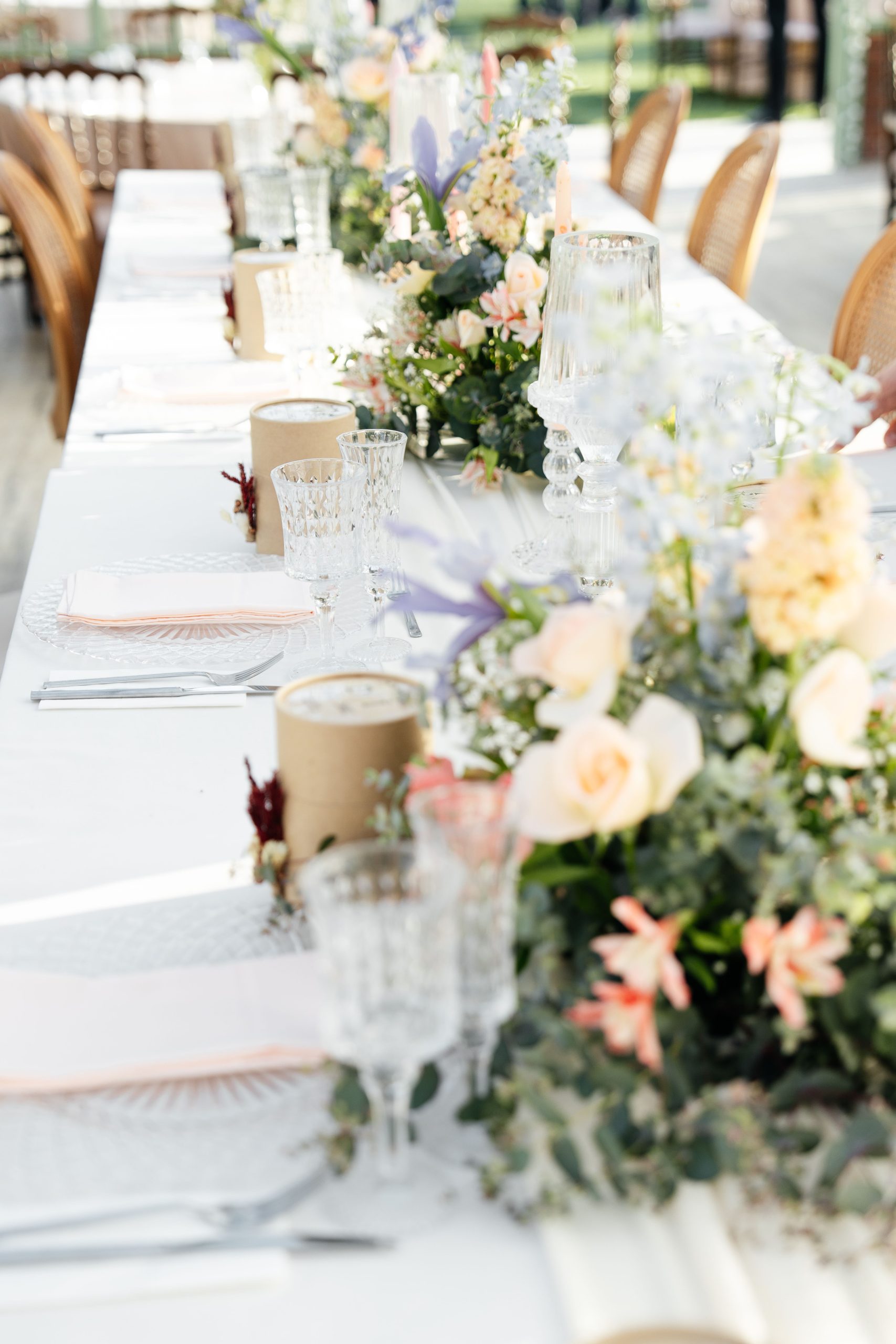 Beautifully decorated wedding reception table with colorful floral centerpieces and elegant glassware.